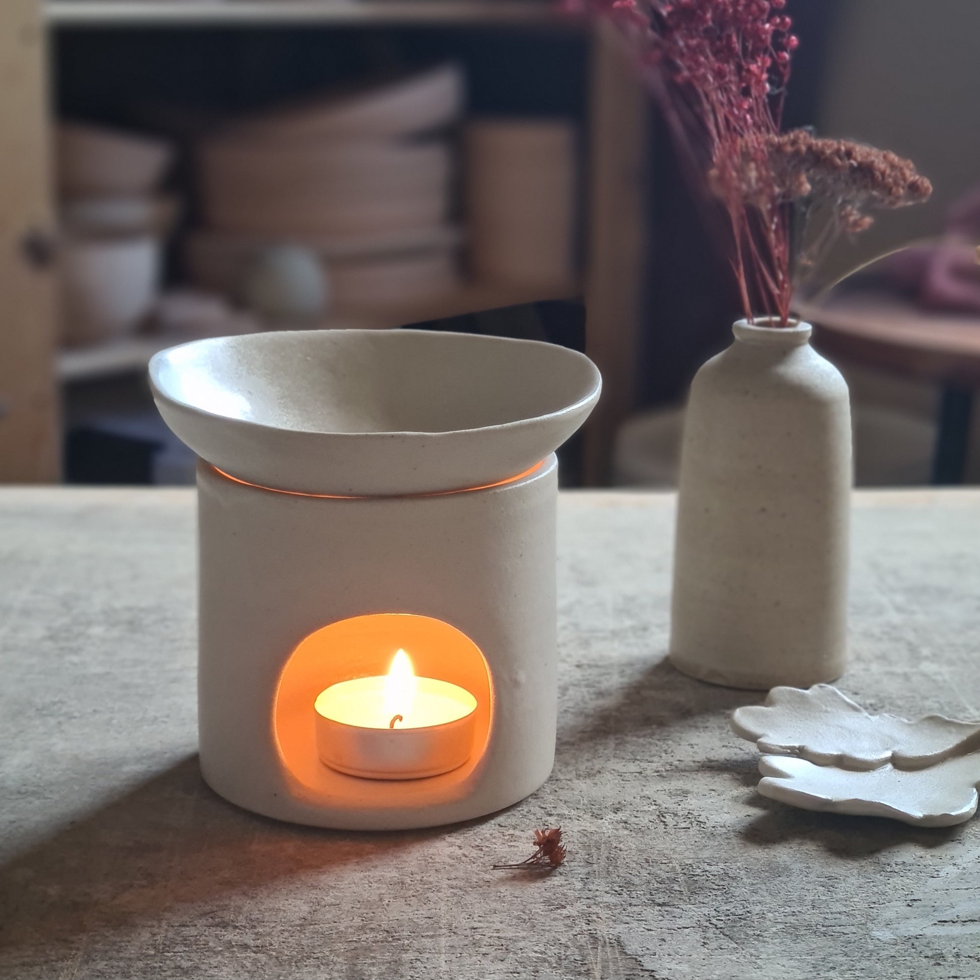 Brûle-parfum artisanal en céramique blanche, bougie allumée pour diffuser des huiles essentielles, coupelle modelée 