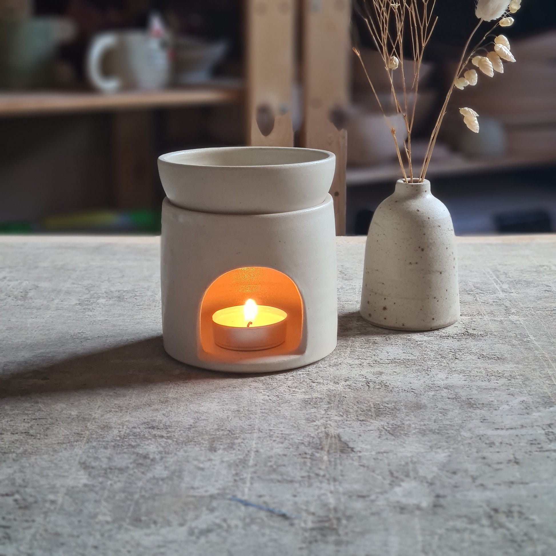 Ambiance douce et chaleureuse avec ce brûle-parfum en grès blanc mat.