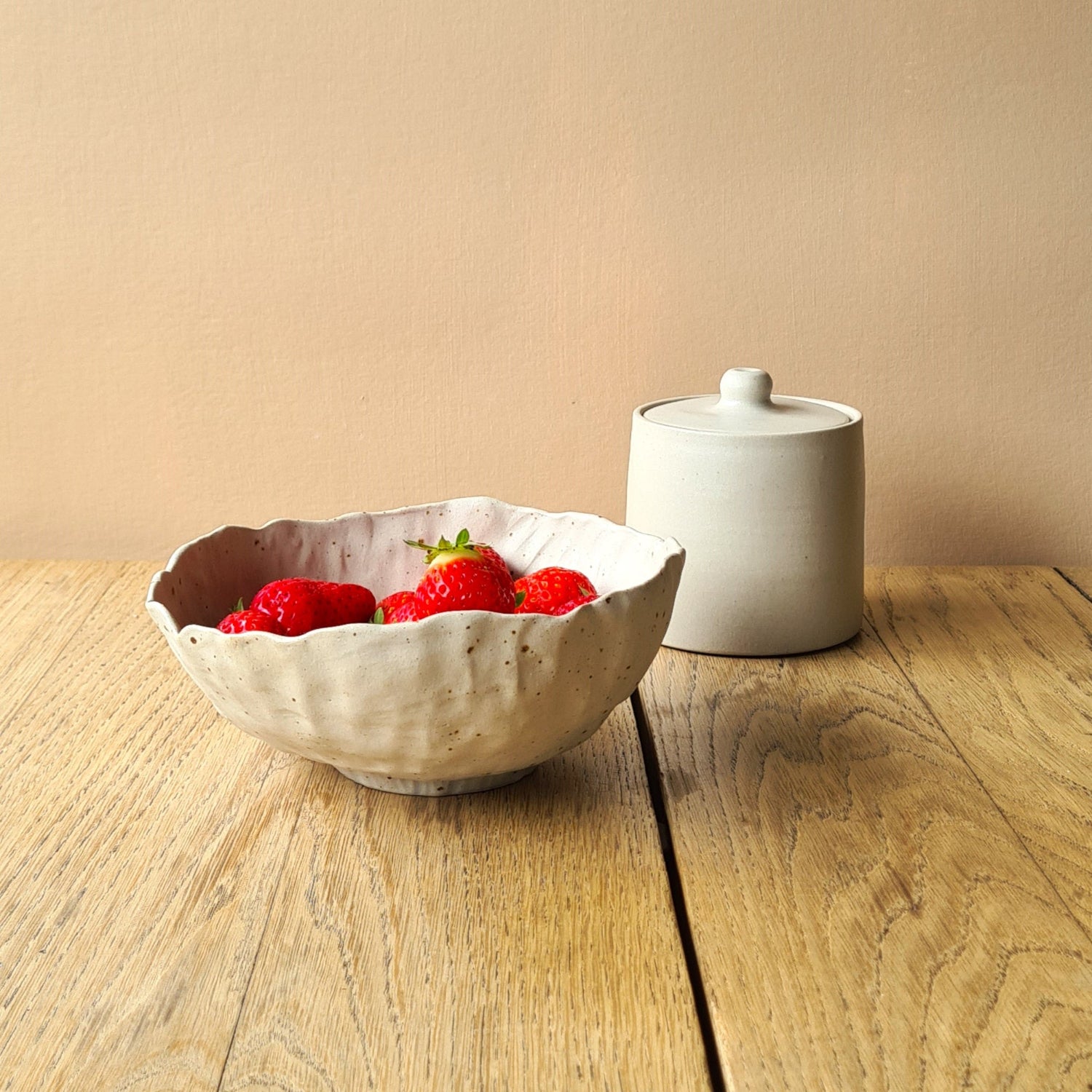 bol rempli de fraises sut table en bois, sucrier en arrière-plan