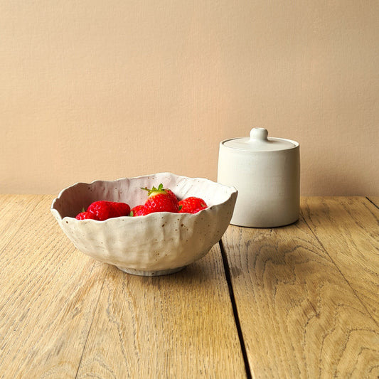 bol rempli de fraises sut table en bois, sucrier en arrière-plan